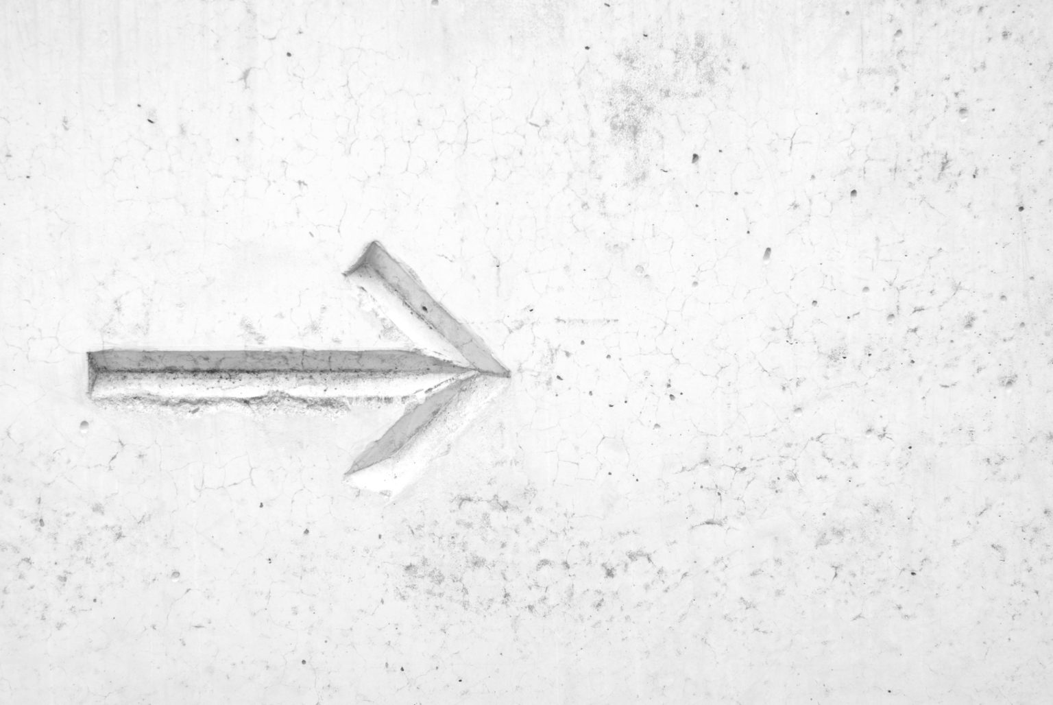 Arrow pointing forward on white marble wall