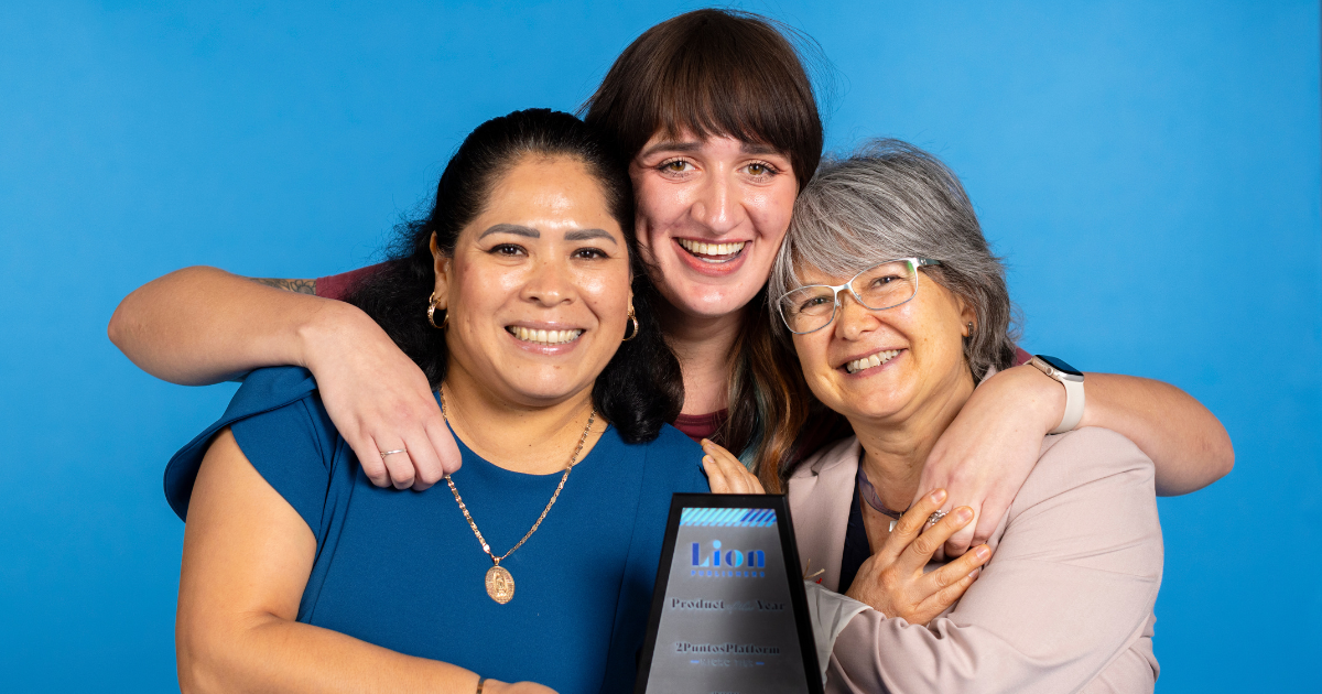 Three women standing together holding an award